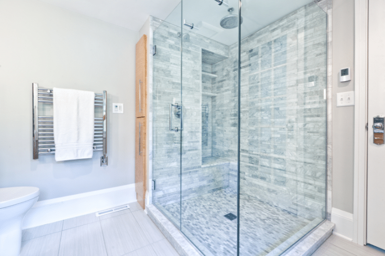 Modern bathroom with a large glass-enclosed shower featuring gray tile walls.